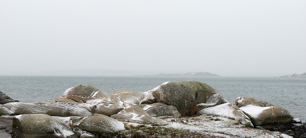 First snow of the season. Rocky coastline of Fiskeback in Gothenburg, Sweden.