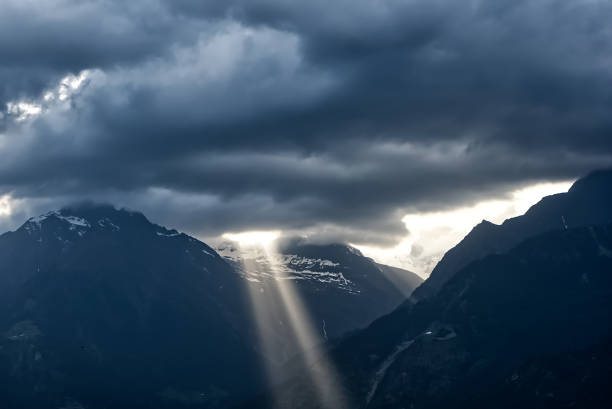 Dramatic sky with sun beams coming through the clouds in Dolomites, European Alps.