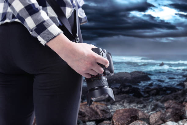 istock Photographer Holding a Camera On a Stormy Coastline 1294925851
