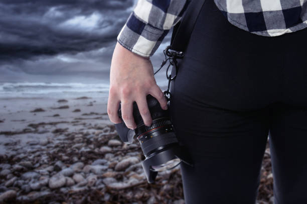 istock Photographer Holding a Camera On a Stormy Coastline 1294925884