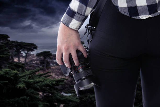 Photographer Holding a Camera On a Stormy Coastline