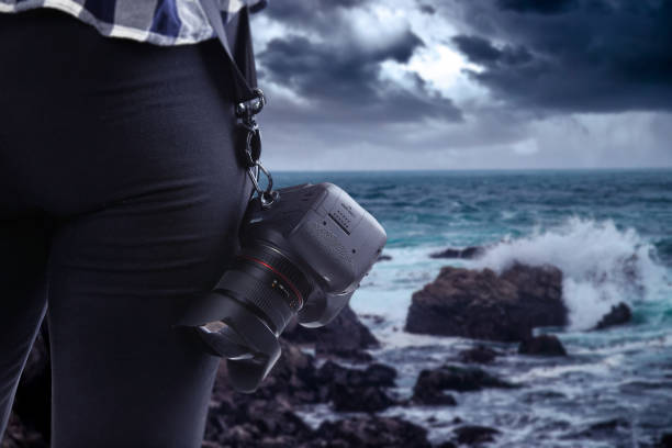istock Photographer Holding a Camera On a Stormy Coastline 1294925897