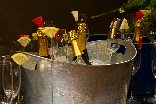 Champagne bottle in a bucket of ice.