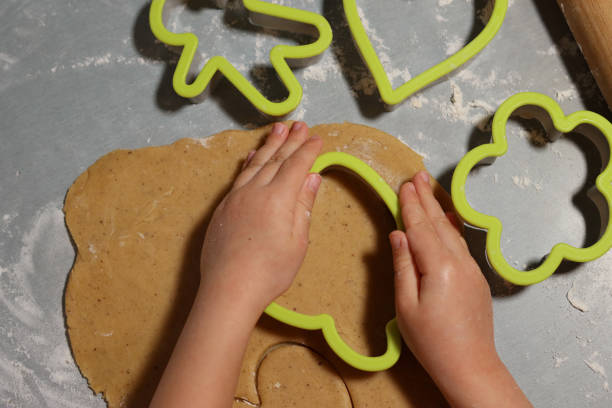 istock Childmakes gingerbread from dough in cookies forms on the table 1294926904