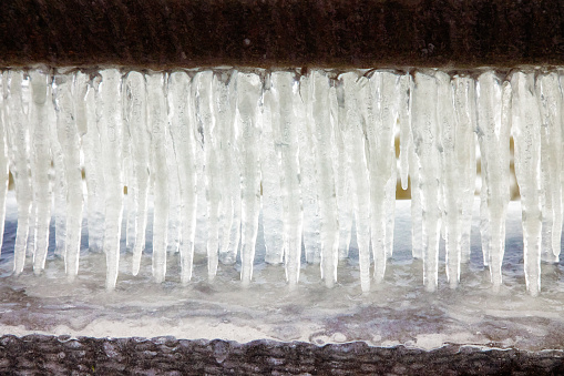 Row of icicles background between two slabs of concrete.