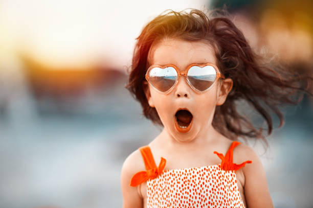 niña bebé sorprendida usando gafas en forma de corazón - surprise child little girls shock fotografías e imágenes de stock