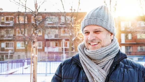 istock Mature man in urban Winter setting smiling while looking away back lit by sunset 1294928385