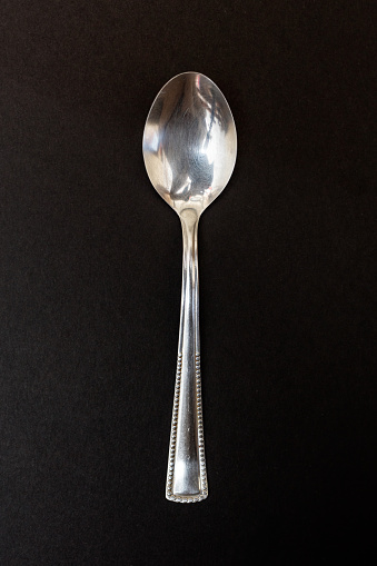Stainless steel teaspoon isolated on black background