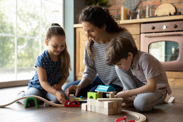istock Happy millennial single mother playing with children on warm floor 1294931280