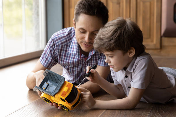 istock Focused little son fix toy car with help of daddy 1294931295
