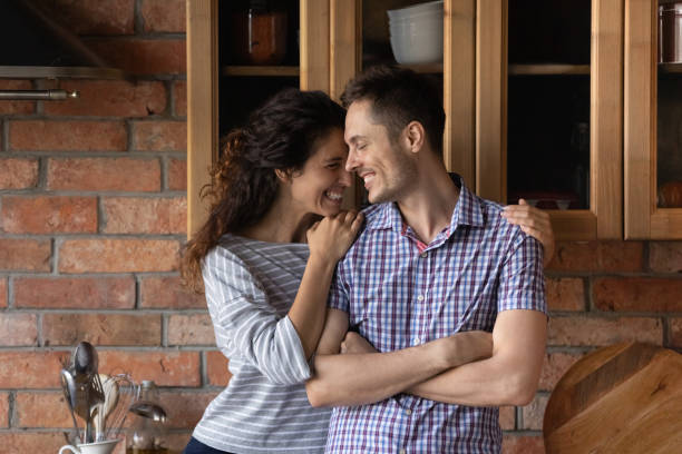 istock Adorable young wife embracing husband beginning romantic evening at kitchen 1294931342