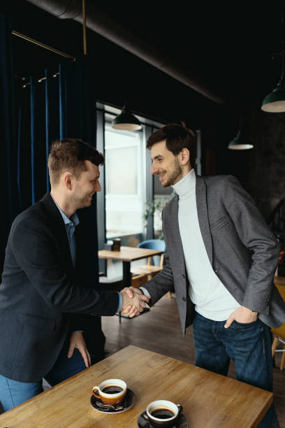 istock Two businessmen shaking hands while meeting in lobby 1294934562
