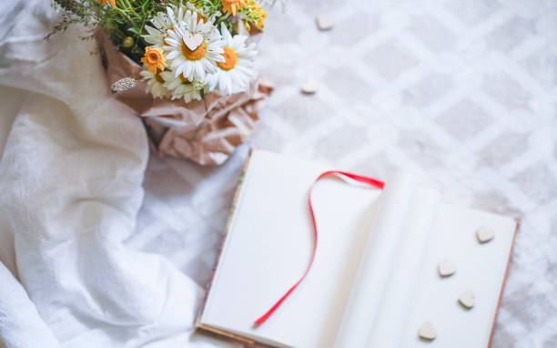 istock Blurred Festive composition with wooden hearts and notebook with blank pages. Top view, copy space. Valentine's day concept. 1294935605