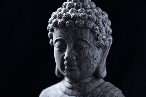 istock Meditating Buddha Statue isolated on black background. 1294939891