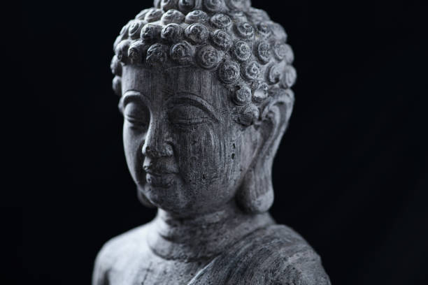 istock Meditating Buddha Statue isolated on black background. 1294942264