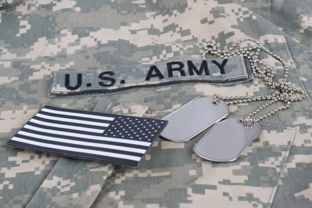 US flag patch with dog tags on camouflage Army Combat Uniform US flag patch with dog tags on camouflage Army Combat Uniform background sergeant badge stock pictures, royalty-free photos & images