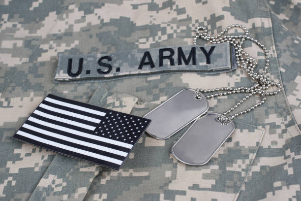 istock US flag patch with dog tags on camouflage Army Combat Uniform 1294943612