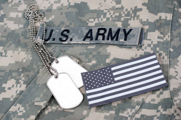 istock US flag patch with dog tags on camouflage Army Combat Uniform 1294943618