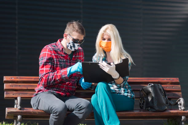 istock colleagues with face mask consulting on bench 1294945959