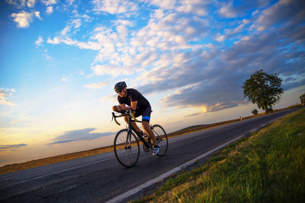 Young man cycling on the road on a sunny day.