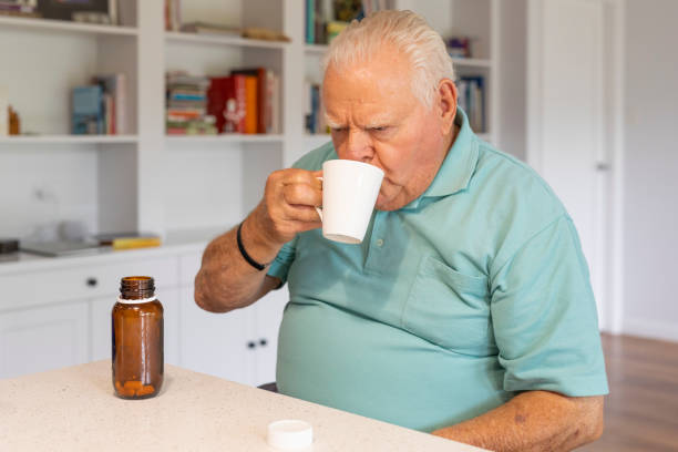 istock Senior Man Taking Medicine Tablets 1294946837