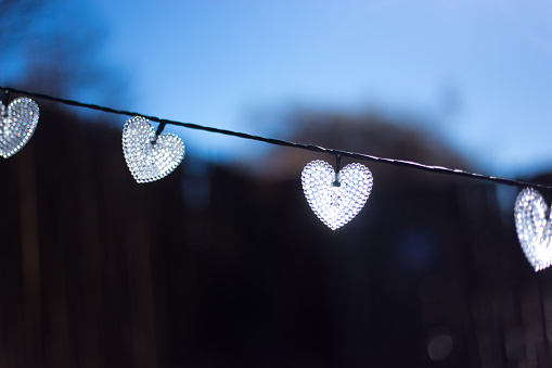 Four Sunlit White Hearts Hanging on a Line
