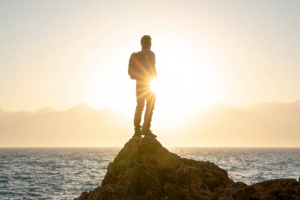 istock Hiker relaxes on sunny coastal ciff at sunrise 1294947800