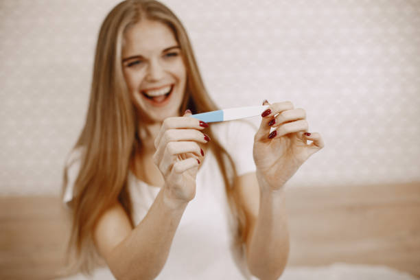 istock Excited woman holding pregnancy test 1294948529