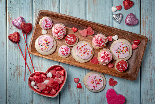 Valentines Day Candy Cupcakes Cookies and Decorations for a Party on Retro Blue Wood Background