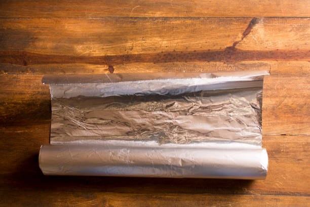istock Shiny Aluminum foil on wooded table. 1294951076