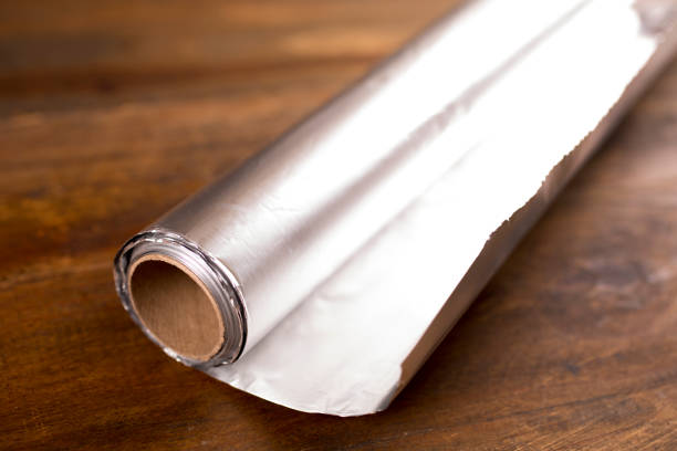 istock Shiny Aluminum foil on wooded table. 1294951668