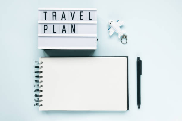 istock Open notepad, airplane, pen and text TRAVEL PLAN 1294954109