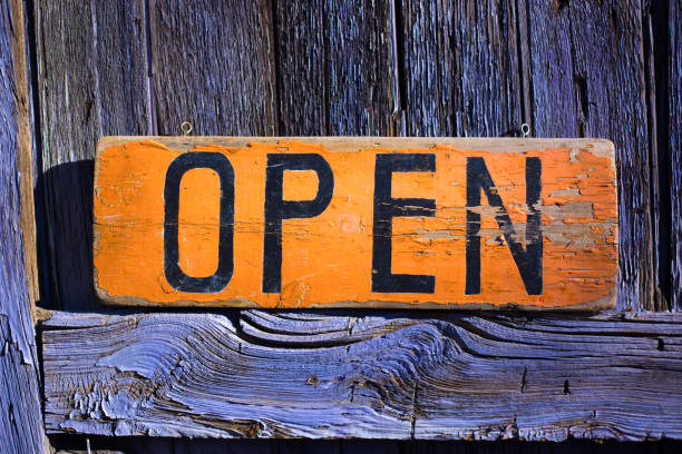 istock Rustic Orange OPEN Sign on Rustic Purple Door 1294955038