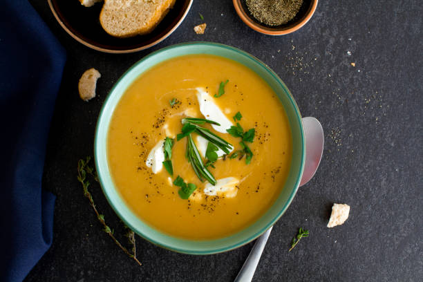 istock Pumpkin soup with cream and herbs. Top view. 1294955084