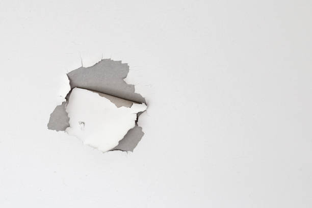 istock White color paint peeling off on ceiling house. Under the roof 1294957726