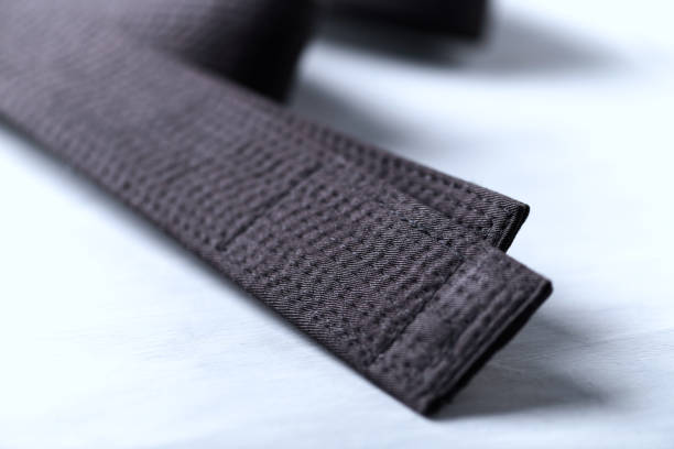 istock Black karate belt on rustic wooden background. Close up. 1294958500