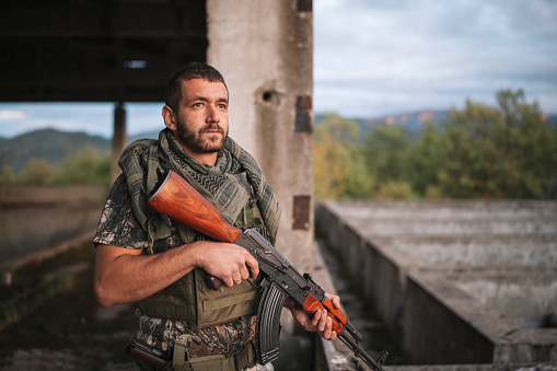 Soldier standing in abandoned building with ak47.