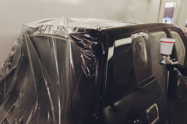istock Worker painting a car in a paint booth, 1294959784