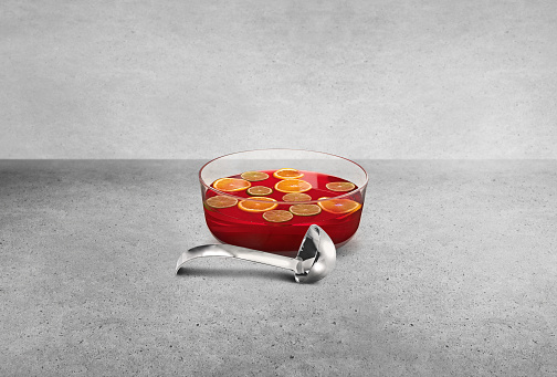 Red fruit punch bowl with oranges & lemons and a ladle on the side