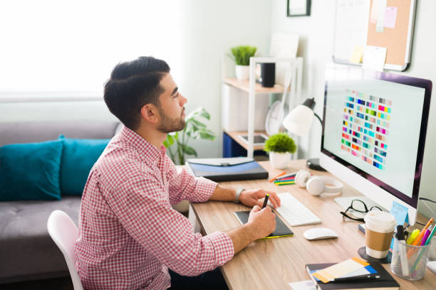 istock Graphic designer working at the computer at his home office desk 1294962899