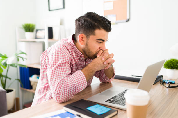 istock Concerned young man sitting at his work desk 1294962932