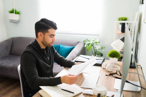 istock Latin young man is reviewing and editing some writings 1294963182