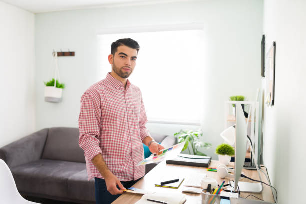 istock Latin young man is standing in front of his office desk 1294963207