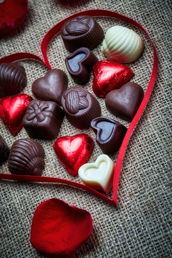 Valentine's Day theme: Chocolate candies in heart shape on a rustic table