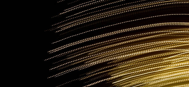 istock golden dashed lines of lights on black background 1294976109