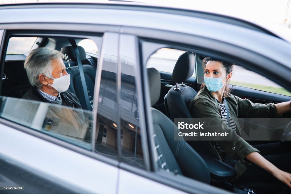 Female rideshare driver in times of the pandemic Female driving a rideshare car in the times of coronavirus pandemic. Crowdsourced Taxi Stock Photo