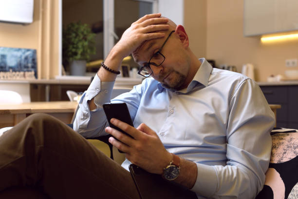 istock man with puzzled look reading message or news item on his mobile phone 1294978421