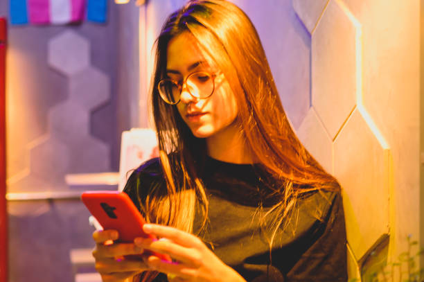 istock a young woman using her cell phone, in a cafeteria in porto alegre 1294979810