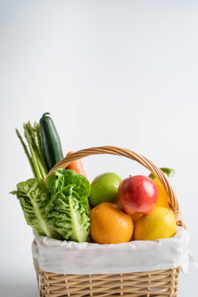 Organic vegetables and fruits in wicker basket isolated on white background. Organic vegetables and fruits in wicker basket isolated on white background. basket healthy eating vegetarian food studio shot stock pictures, royalty-free photos & images
