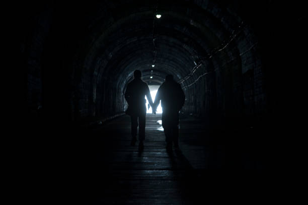 istock couple holding hands in a dark underpass 1294985009